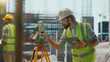 © Videophilia - Surveyor using theodolite and digital tablet at construction site