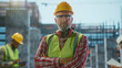 © Videophilia - Confident construction worker posing at building site with crossed arms