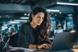 © nana - Focused financial specialist latin hispanic businesswoman working on laptop pc sitting at desk in modern office. Middle eastern or european woman using computer for finance data analysing work online