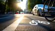 © Curioso.Photography - A bicycle lane symbol painted on asphalt, with blurred cars and trees in the background, suggesting urban mobility.
