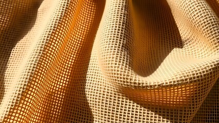Close up of a textured beige mesh fabric with folds