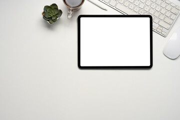 Wall Mural - an office desk with blank tablet screen, coffee cup, and green plant