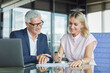 © Westend61 - Businesswoman and businessman communicating and working together in office