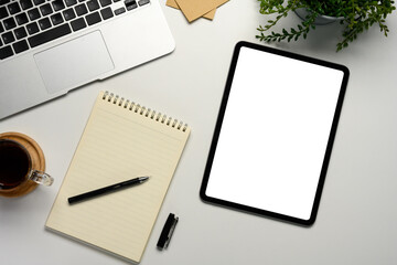 Wall Mural - flat lay of workspace featuring digital tablet with empty screen, laptop, notebook and coffee cup