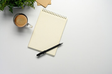 Wall Mural - flat lay of a blank notebook with coffee and pen on white desk