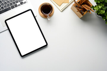 Wall Mural - digital tablet with blank screen, coffee cup, laptop, and notebook on a clean white desk