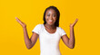 © Prostock-studio - Excited african american woman winner raising hands up with great happiness, winning game, having success, victory and triumph concept, panorama, yellow background