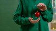 © VISTA by Westend61 - Hand holding a red Christmas bauble at home for the holiday season