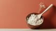 © JuanB - Minimal wooden bowl with white flour and spoon against terracotta orange background with rustic lighting