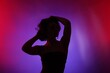 © New Africa - Silhouette of woman posing in neon lights on color background