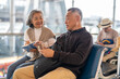 © Art_Photo - Senior asian couple sitting with luggage checking passport planning trip showing travel preparation at airport, retirement lifestyle enjoying international travel, safe travel, elderly trip insurance