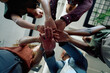 © StratfordProductions - Directly below closeup of diverse business people stacking hands in office during daytime