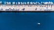 © AmazingAerialAgency - Aerial view of a long pier lined with boats contrasting with the deep blue sea, a lone boat cruising leaving a trail, Split, Split-Dalmatia County, Croatia.