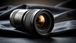 © Simone Matos - Camera lens placed on dark fabric background with soft lighting