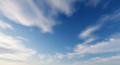 © aldynata - A serene view looking up at a vast blue sky with scattered, wispy white clouds.