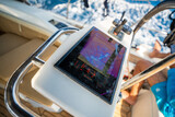 View from above of a man steering a sailing yacht using navigation display and control panel near Croatia. Precision, control and modern sailing lifestyle at sea.
