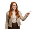 © Lunapix - Confident young businesswoman pointing to blank copy space. A smiling red-haired female professional presenting an idea.