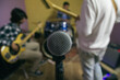 © TrueShot | Westend61 - Microphone with music band rehearsing in background
