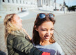 Austria, Vienna, two young women having fun in front of the parliament building