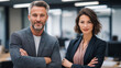 © Furkan - Confident Business Executives Standing with Arms Crossed in a Professional Office Setting