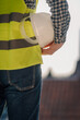 © Ljustina - Construction worker holding hardhat at construction site