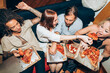 © TrueShot | Westend61 - Friends enjoying pizza during social gathering at home