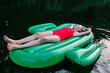 © TrueShot | Westend61 - Girl wearing red swimwear relaxing on pool raft over river
