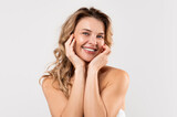 Positive Beautiful Middle Aged Female Posing Over Light Grey Background, Portrait Of Attractive Mature Female With Smooth Skin Touching Face And Smiling At Camera, Enjoying Self-Care Routine