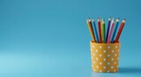 Colorful pencils in a polka-dotted container against a blue background (1)