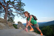© bilanol - Hiker woman clambering on rocky mountain footpath in summer nature. Lonely female traveler traversing hard wilderness trail. Healthy lifestyle and sport concept