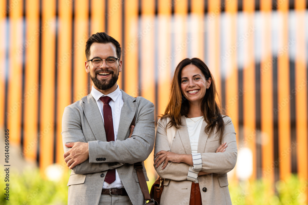 Portrait of smiling business people with arms crossed in front of ...