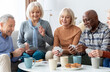 © Prostock-studio - Multiracial group of happy senior people sitting on couch, playing cards, drinking tea, eating cookies at nursing home, enjoying time together. Residential facilities, assisted living concept