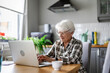 © pikselstock - Senior woman using laptop at home
