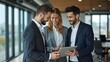 © Konstantin - Business people standing in an office and using a laptop