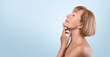© Prostock-studio - Side view of feminine nude senior woman touching silky skin on her neck, light studio background. Charming mature lady taking care of her face and body, pampering herself. Aged beauty concept
