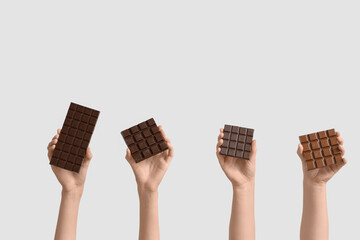 Wall Mural - Female hands with different sweet chocolate  bars on white background