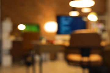Wall Mural - blurred view of programmer's office with desks and glowing lamps in evening