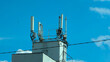 © Илкин Абдуллаев - Mobile phone antennas on the roof of a building against the blue sky