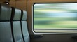© Erisna Yolanda - Inside a train car, two empty seats face a window blurring the passing landscape