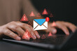 © Nirusmee - A man typing on a laptop with warning email icons, representing email threat, phishing attack, malware, data breach, cybersecurity alert, scam message, spam risk, and online fraud protection.
