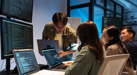 asian man presents code during a software development meeting or coding workshop, guiding attendees 
