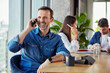 © BusinessClass by W61 - Happy businessman talking on smart phone at desk