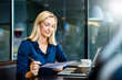 © BusinessClass by W61 - Smiling mature businesswoman doing paperwork at cafe