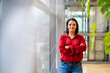 © BusinessClass by W61 - Smiling businesswoman standing with arms crossed by window in office