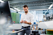 © BusinessClass by W61 - Businessman looking at machine part in factory