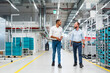 © BusinessClass by W61 - Two businessmen walking and talking in a factory