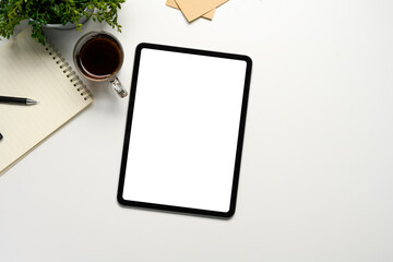 Wall Mural - flat lay of digital tablet mockup on white desk with coffee, notepad, and plant