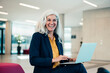 © BusinessClass by W61 - Laughing businesswoman with laptop sitting in office