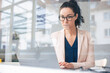© BusinessClass by W61 - Serious businesswoman working on laptop seen through glass