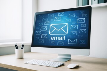 Wall Mural - desktop computer with email icon on screen in modern office environment with light background, symbo